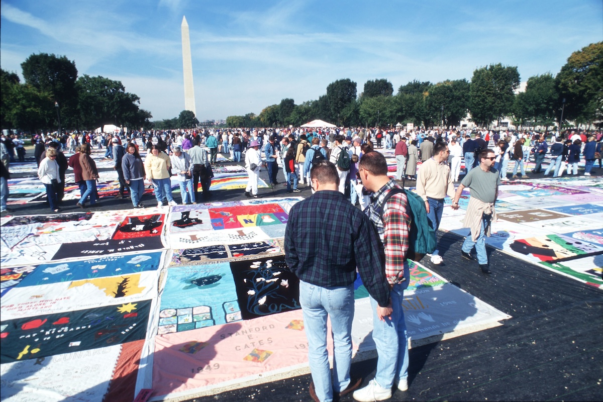 Spectators look at the National AIDS Memorial Quilt on the Mall October 12, 1996 in Washington, DC. (Photo by Evan Agostini/Liaison)