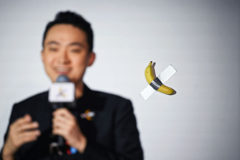 Chinese-born crypto founder Justin Sun speaks before eating a banana artwork composed of a fresh banana stuck to a wall with duct tape, in Hong Kong on November 29, 2024, after buying the provocative work of conceptual art by Italian artist Maurizio Cattelan at a New York auction for $6.2 million. (PETER PARKS/AFP via Getty Images)