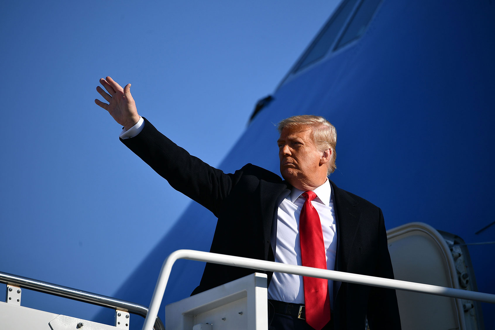 US President Donald Trump waves to the media as he makes his way to board Air Force One before departing from Andrews Air Force Base in Maryland on January 12, 2021. (MANDEL NGAN/AFP via Getty Images)