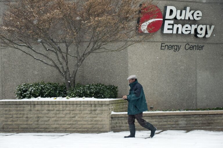 A man walks past one of two buildings that house Duke Energy's headquarters January 10, 2011 in Charlotte, North Carolina. (Photo by Davis Turner/Getty Images)