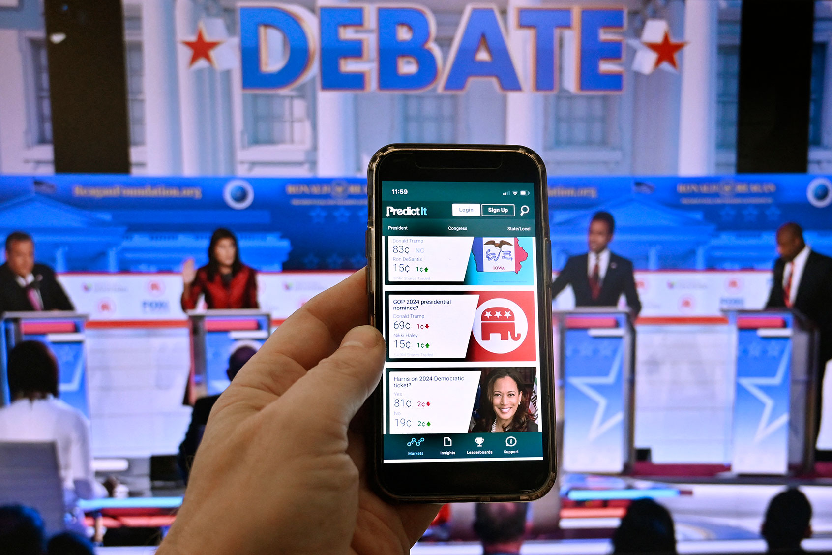 This photo illustration taken in Washington, DC, on November 1, 2023, shows a phone screen displaying PredictIt, the online prediction market with a picture of the second Republican presidential primary debate at the Ronald Reagan Presidential Library in Simi Valley, California. (OLIVIER DOULIERY/AFP via Getty Images)