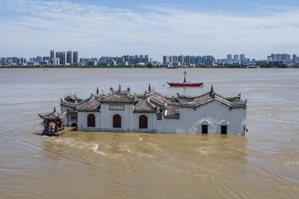 The photo taken on July 6, 2024 shows an aerial view of a partially submerged Guanyin temple in floodwaters in the swollen Yangtze River, in Ezhou, in central China's Hubei province. China is enduring a summer of extreme weather, with flooding across central and southern regions as much of the north swelters through rolling heat waves. (Photo by AFP / China OUT Photo by STR/AFP via Getty Images)