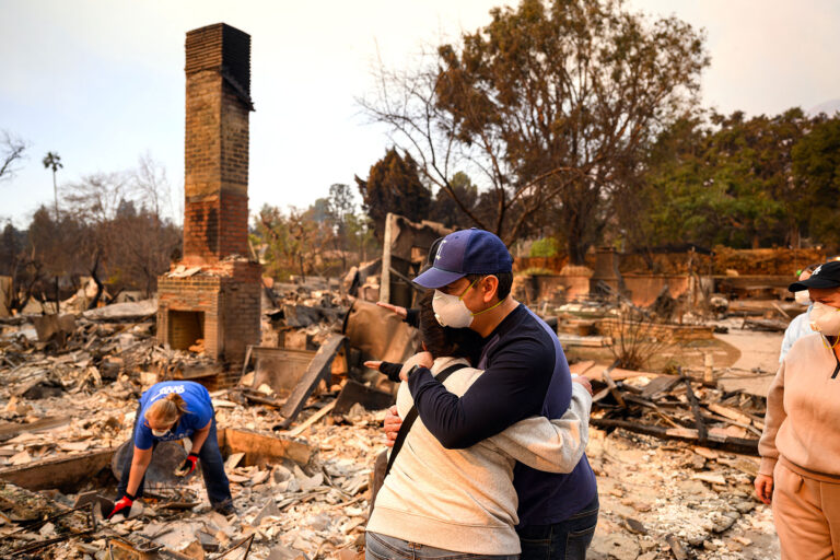 Family members embrace while viewing their burned home during the Eaton fire in the Altadena area of Los Angeles county, California on January 9, 2025. (JOSH EDELSON/AFP via Getty Images)