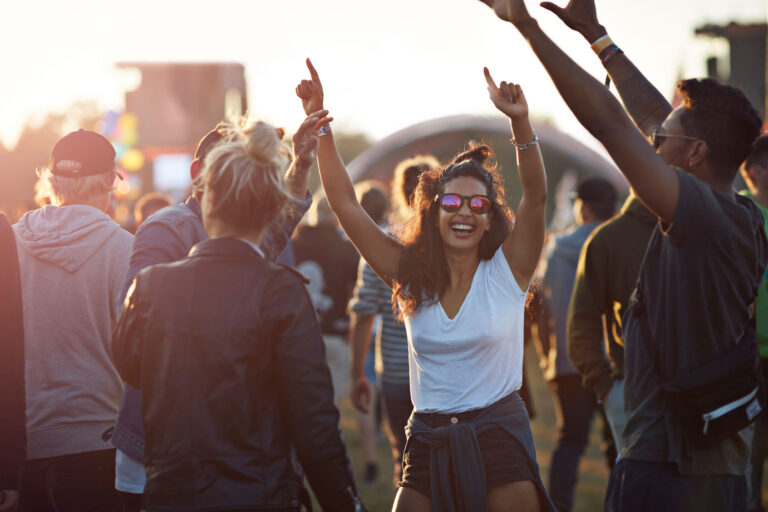 Friends hanging out at a music festival, at sunset (Getty Images/Klaus Vedfelt)