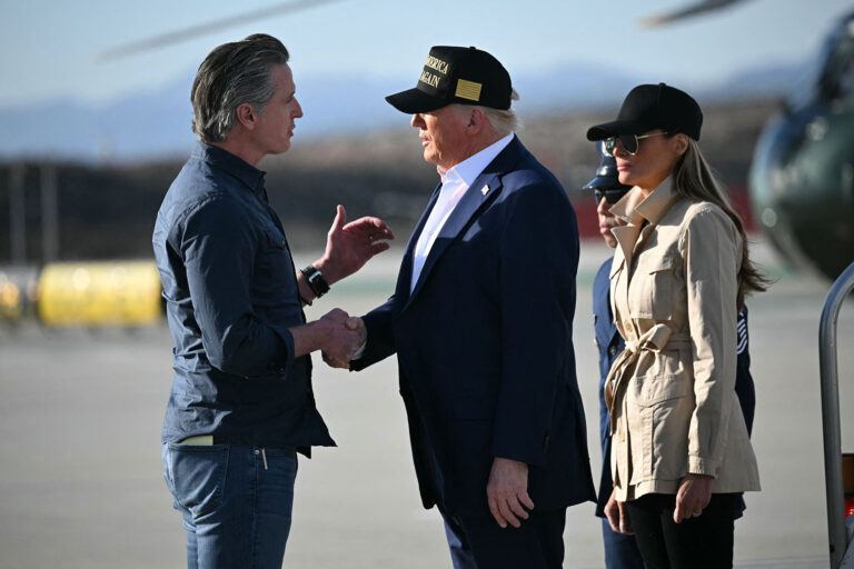 US President Donald Trump followed by First Lady Melania Trump, shakes hands with California Governor Gavin Newsom upon arrival at Los Angeles International Airport in Los Angeles, California, on January 24, 2025, to visit the region devastated by the Palisades and Eaton fires. (MANDEL NGAN/AFP via Getty Images)