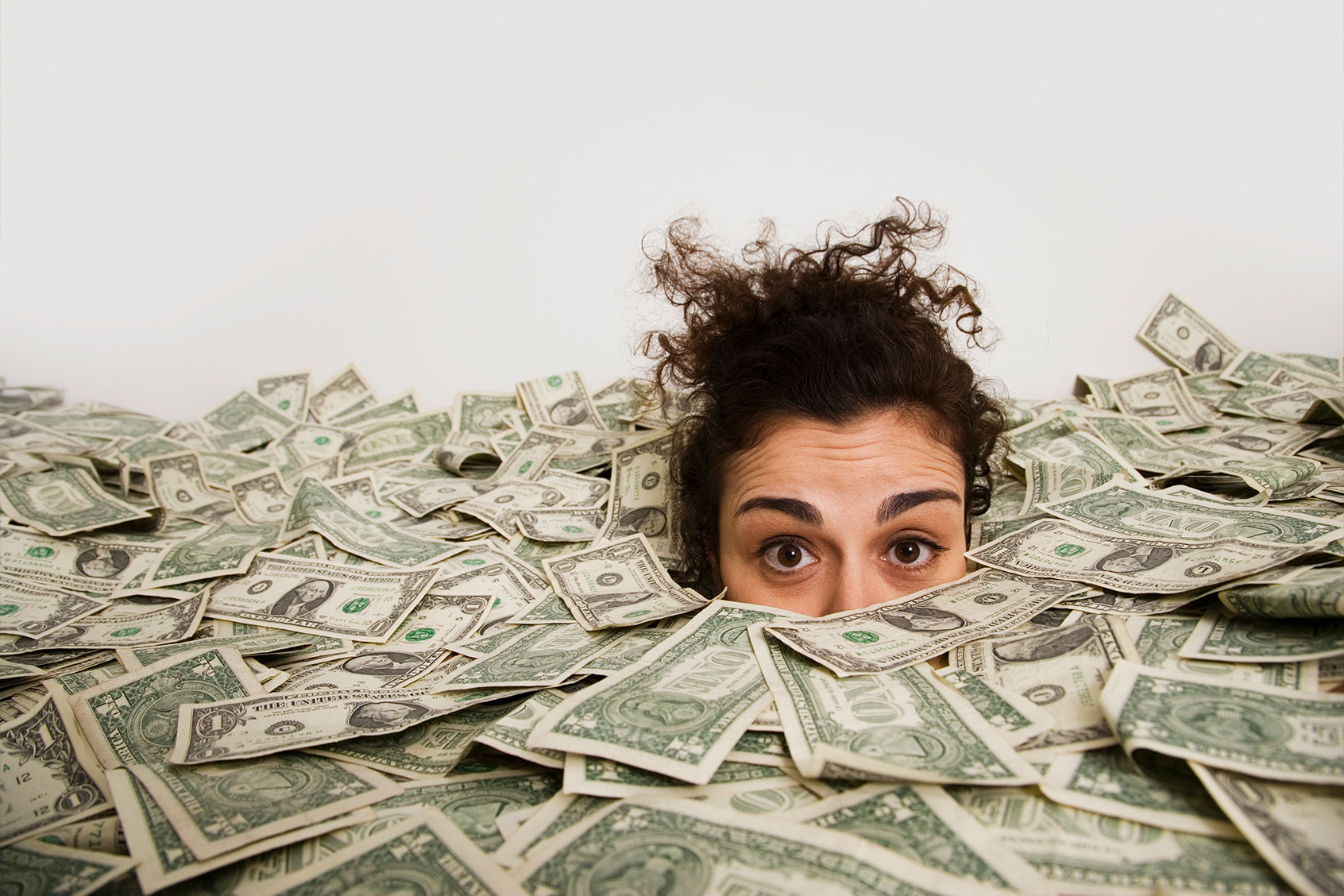 Woman up to her eyes in money (Getty Images/John M Lund Photography Inc)