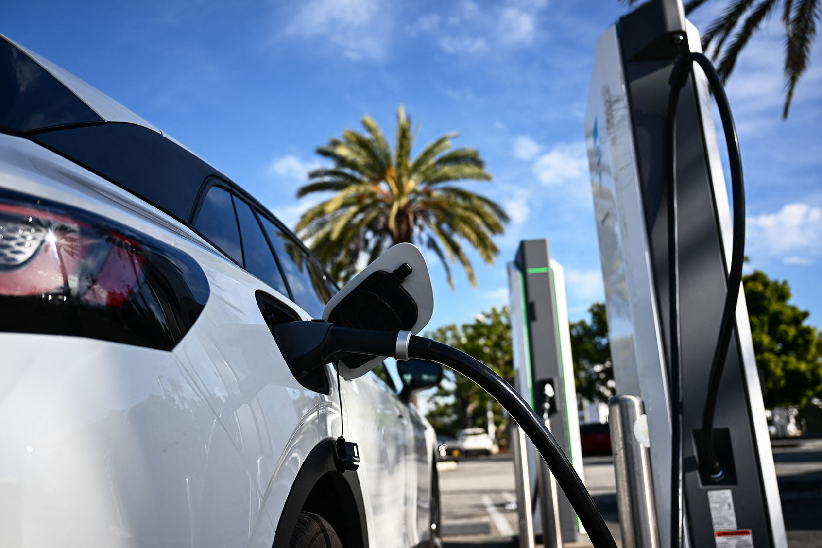 An electric vehicle (EV) charges via a CCS DC fast charger from Electrify America at a shopping mall parking lot in Torrance, California, on February 23, 2024. (PATRICK T. FALLON/AFP via Getty Images)