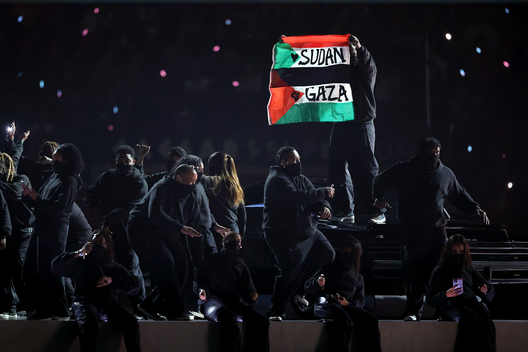A protester holds a flag onstage during Apple Music Super Bowl LIX Halftime Show at Caesars Superdome on February 09, 2025 in New Orleans, Louisiana. (Emilee Chinn/Getty Images)