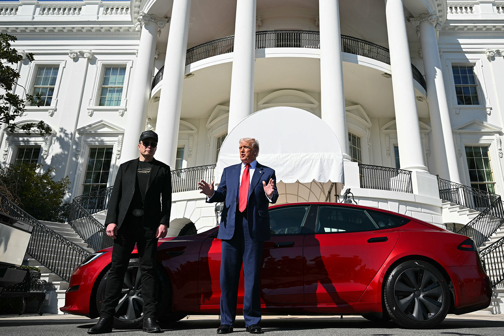 President Donald Trump and Tesla CEO Elon Musk speak to the press as they stand next to a Tesla vehicle on the South Portico of the White House on March 11, 2025 in Washington. (Mandel Ngan / AFP via Getty Images)