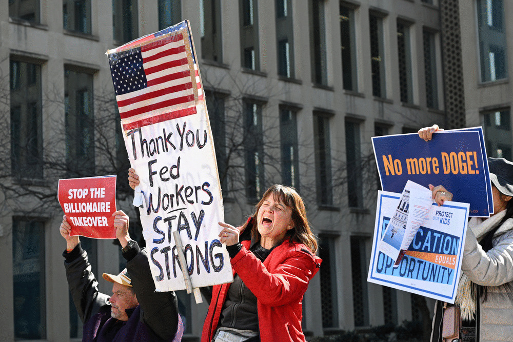 Protesters hold signs in solidarity with the American Federation of Government Employees of District 14 at a rally in support of federal workers at the Office of Personnel Management in Washington, DC, March 4, 2025. (ALEX WROBLEWSKI/AFP via Getty Images)