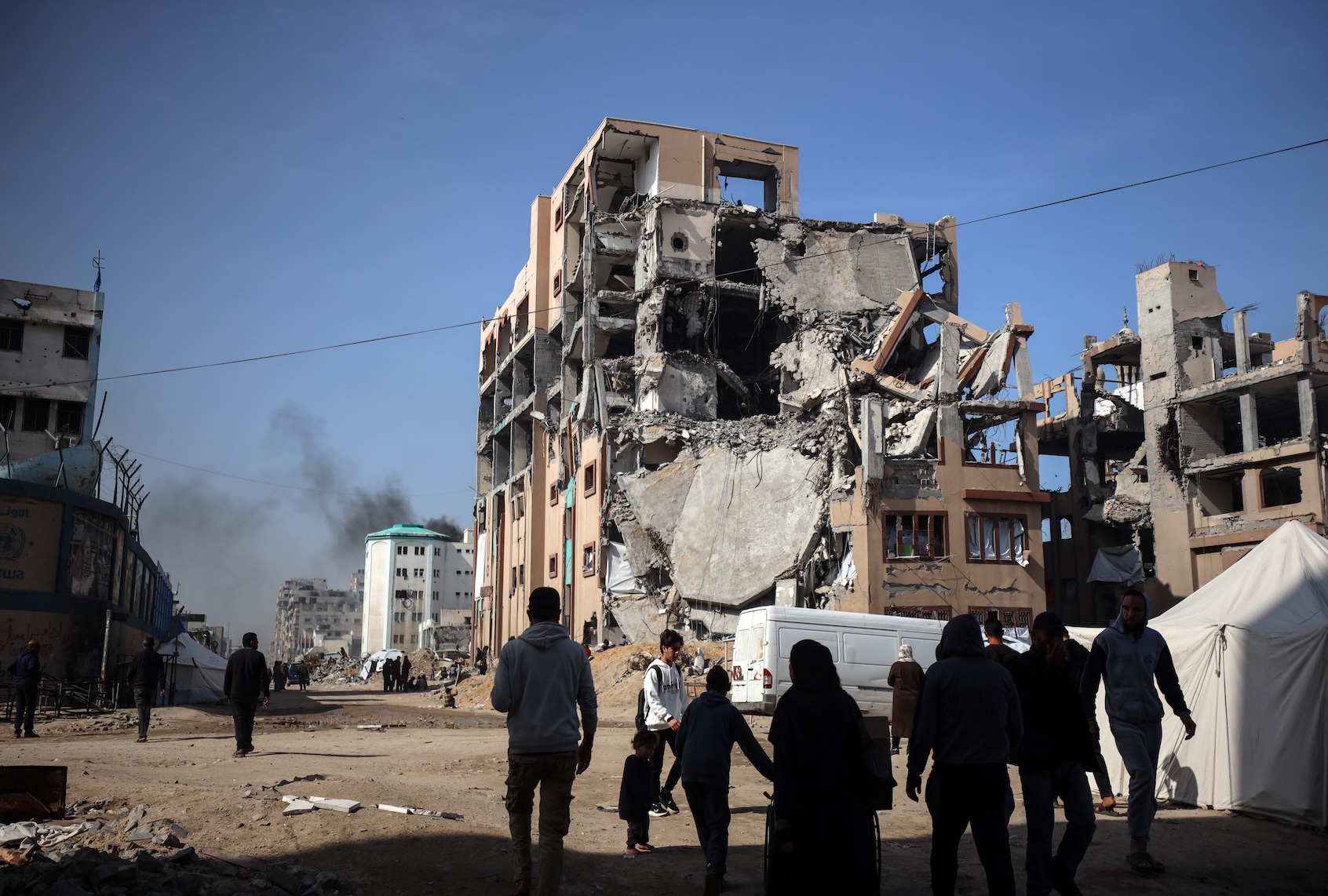 Displaced Palestinians walk outside the destroyed Islamic University in Gaza City, on March 25, 2025. Israel vows to destroy the Palestinian militant group Hamas and resumes intense bombardment of Gaza on March 18, redeploying ground troops and shattering a truce that has largely held since January 19. (Photo by Majdi Fathi/NurPhoto via Getty Images)
