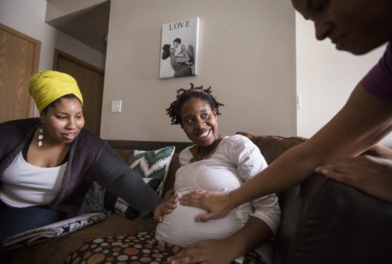 Clara Sharp, left, and Sonja Watley, right, both doulas and co-directors of the company Ahavah Birthworks, visit expectant mother Claire Littleton, center, who is on Medicaid, at her home in north Minneapolis on Wednesday, January 13, 2016. (Photo by Leila Navidi/Star Tribune via Getty Images)