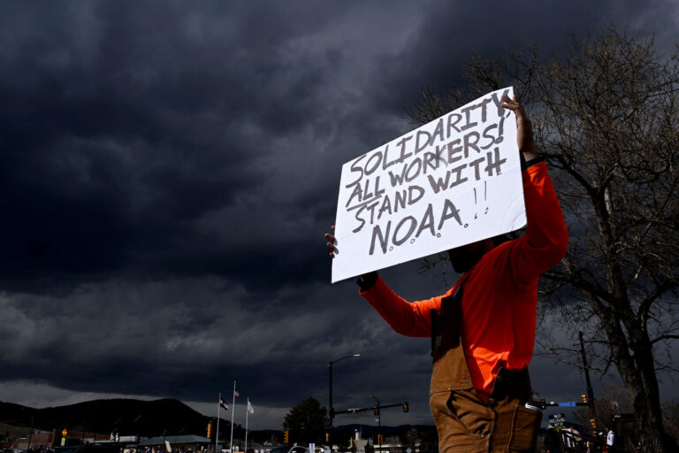 A man who did not want to be identified holds up a sign while standing along Broadway as he joins hundreds of others during a large rally and protest outside of NOAA in Boulder, Colorado on March 3, 2025. (Helen H. Richardson/MediaNews Group/The Denver Post via Getty Images)