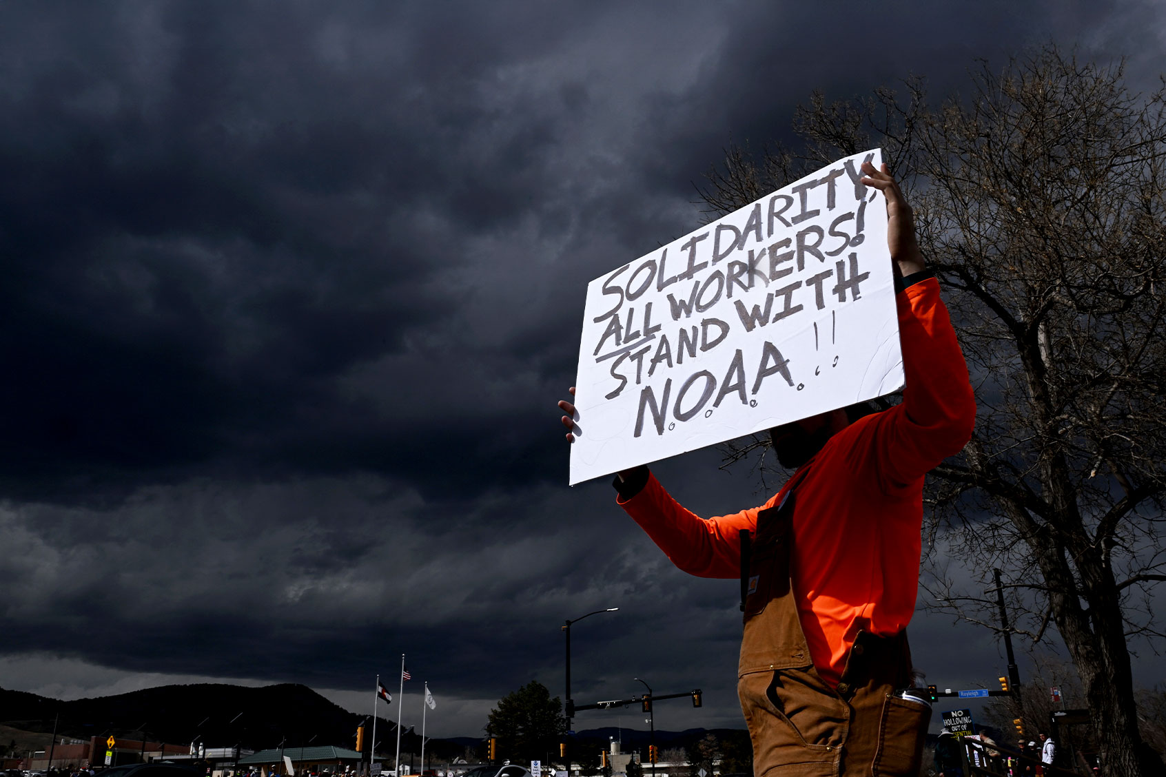 A man who did not want to be identified holds up a sign while standing along Broadway as he joins hundreds of others during a large rally and protest outside of NOAA in Boulder, Colorado on March 3, 2025. (Helen H. Richardson/MediaNews Group/The Denver Post via Getty Images)