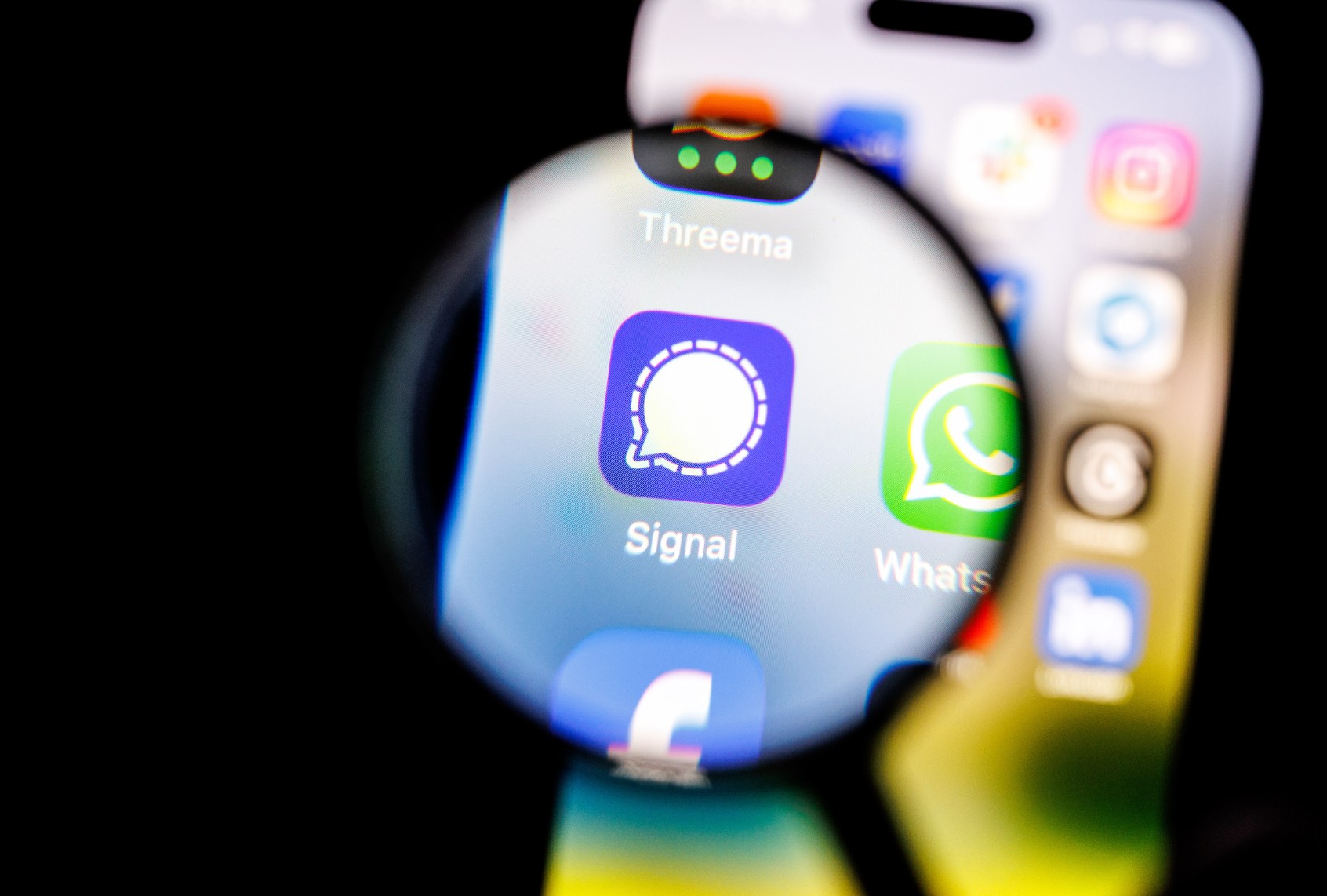 The Signal app logo can be seen through a magnifying glass on the display of a smartphone on February 19, 2025. (Matthias Balk/picture alliance via Getty Images)