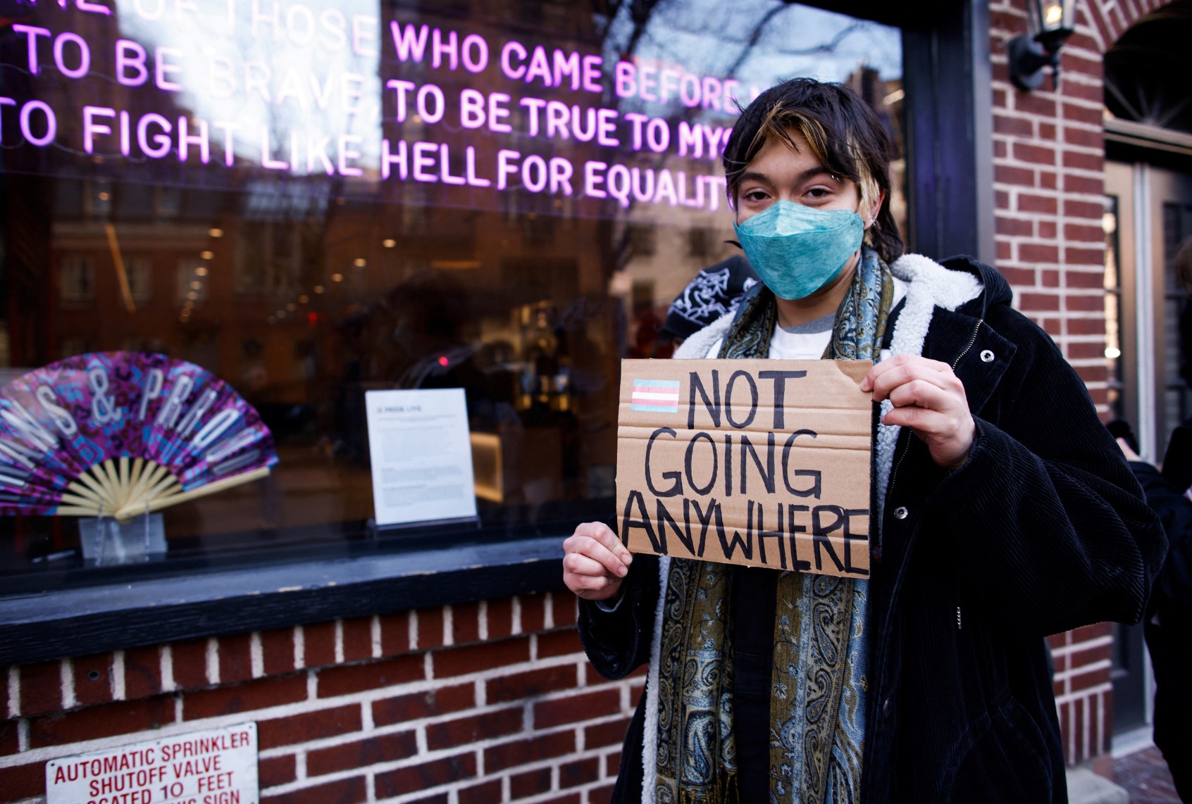 A person holds a sign outside the Stonewall Inn in New York, the scene of riots against police raids on the gay bar in 1969, on February 14, 2025, during a protest after the word transgender was erased from the National Park Service's webpage about the riots. (KENA BETANCUR/AFP via Getty Images)