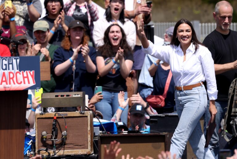 U.S. Rep. Alexandria Ocasio-Cortez waves to a cheering crowd while making the stage at the Fighting Oligarchy rally at Gloria Molina Grand Park in downtown Los Angeles on April 12, 2025. (Genaro Molina/Los Angeles Times via Getty Images)