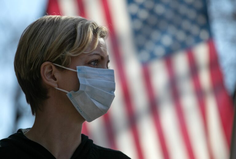 Coronavirus crisis volunteer Rhiannon Navin greets local residents arriving to a food distribution center at the WestCop community center on March 18, 2020 in New Rochelle, New York. New Rochelle has been a hot spot for the COVID-19 pandemic in the U.S. (Photo by John Moore/Getty Images)