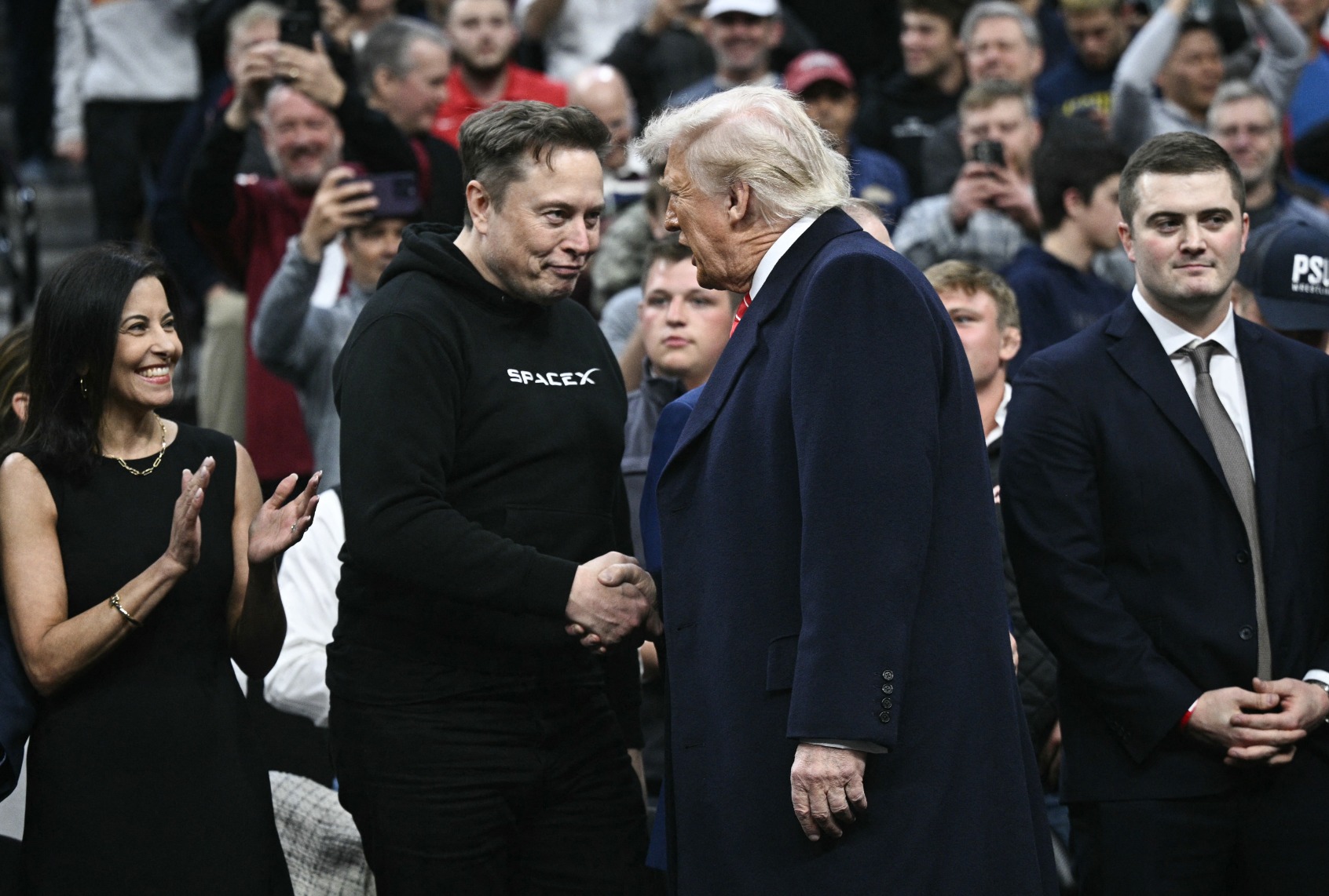 Tesla and SPaceX CEO Elon Musk and President Donald Trump shake hands as they attend the men's NCAA wrestling competition at the Wells Fargo Center in Philadelphia, Pennsylvania, on March 22, 2025. (BRENDAN SMIALOWSKI/AFP via Getty Images)