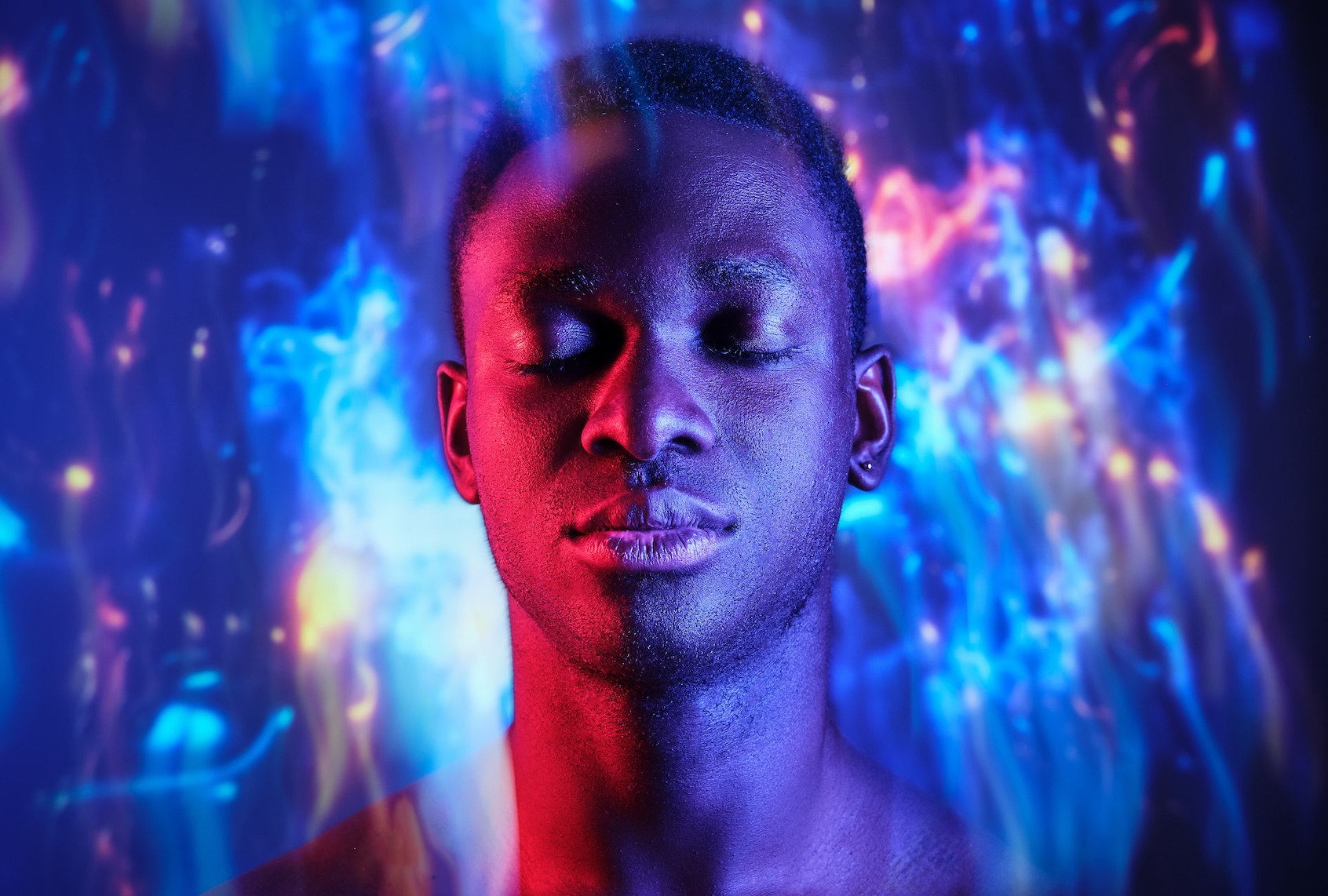Man with eyes closed standing in blurred light. (Addictive Stock / Getty Images)