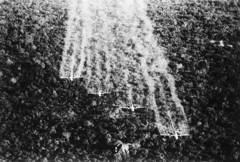 9/30/1965 - Tan Son Nhut, South Vietnam: A flight of four United States Air Force Ranch Hand C-123s spray a Viet Cong jungle position near here with a defoliating liquid. The four specially equipped aircraft cover a swath of more than 1,000 feet wide on each pass over the dense jungle. (Getty Images / Bettmann)