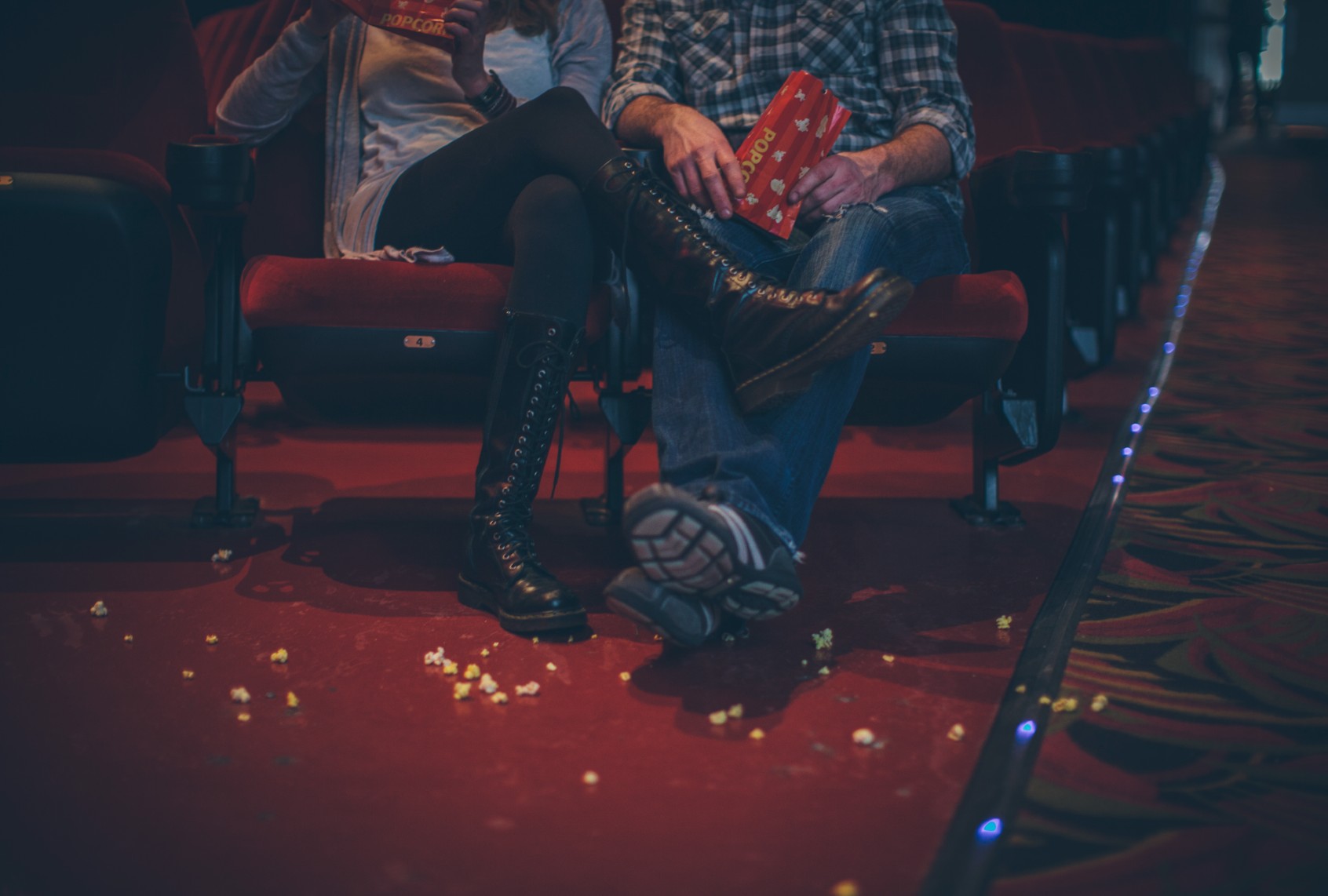 Couple with popcorn on the floor at the movie theater. (EVOK/R.Lauren/Getty)