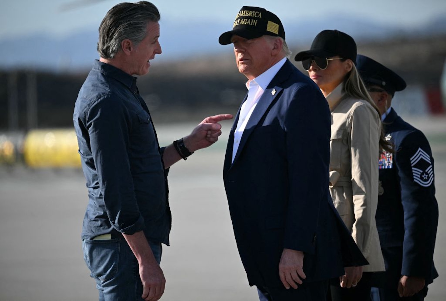 California Gov. Gavin Newsom talks with President Donald Trump as First Lady Melania Trump looks on after the First Couple's arrival at Los Angeles International Airport on January 24, 2025.