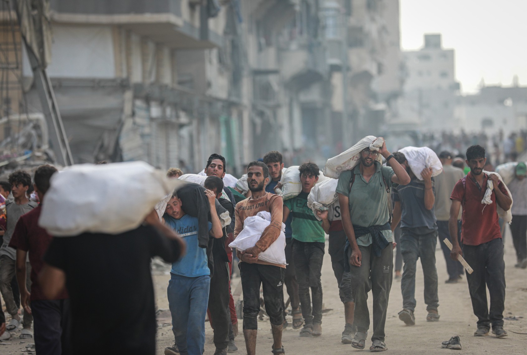 Palestinians carry the aid bags following the Israeli army attack on Palestinians who had gathered to receive aid in the Zakim area in Gaza City, Gaza on June 22, 2025. (Abdalhkem Abu Riash/Anadolu via Getty Images)