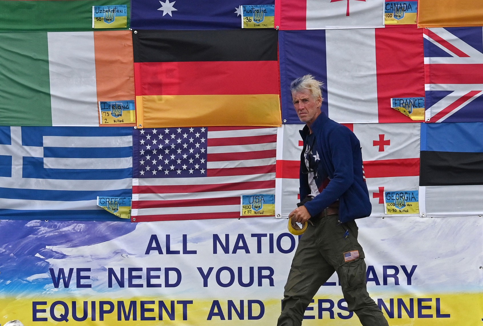 This photograph taken on Independence Square in Kyiv on June 23, 2022 shows U.S. citizen Ryan Wesley Routh sticking up national flags of the countries helping Ukraine. (SERGEI SUPINSKY/AFP via Getty Images)