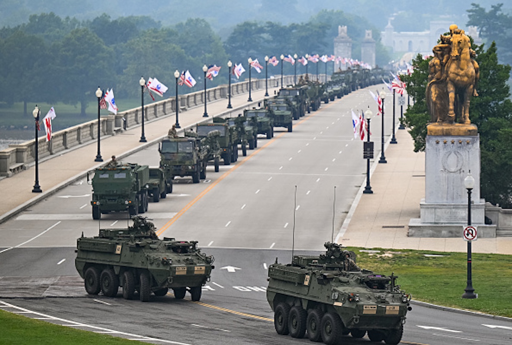 Members of the U.S. Army and armored vehicles move across the Memorial Bridge during the Army 250th Anniversary Parade in Washington, D.C., on June 14, 2025. President Donald Trump reveled in a long dreamt-of military parade on his 79th birthday Saturday, as demonstrators across the country branded him a dictator in the biggest protests since his return to power. (ANNABELLE GORDON/AFP via Getty Images)