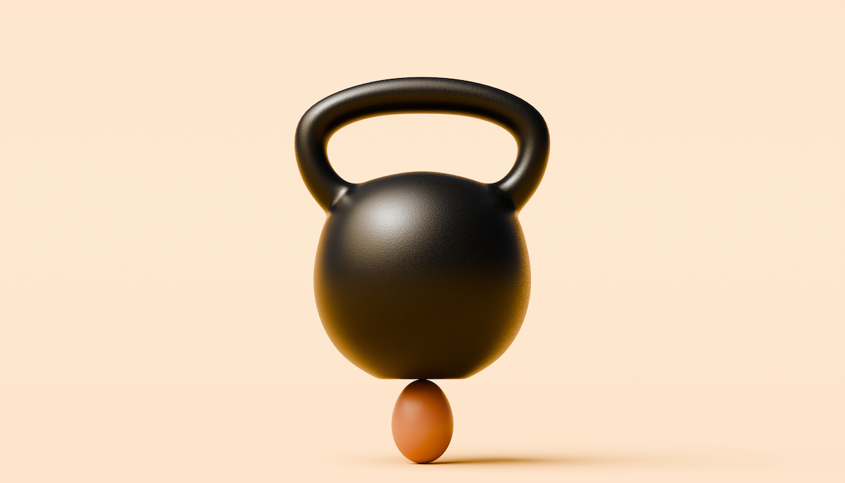 A kettlebell balances on an egg (J Studios / Getty Images)