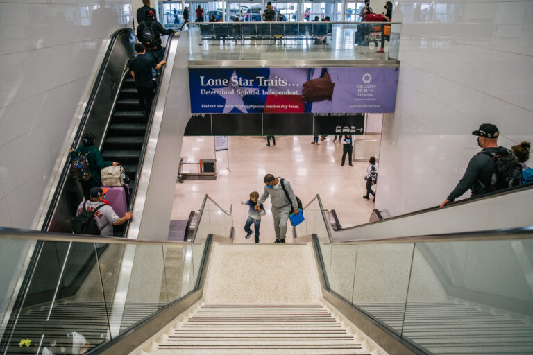 HOUSTON, TEXAS - DECEMBER 03: A father walks up steps with his child at George Bush Intercontinental Airport (Photo by Brandon Bell/Getty Images)