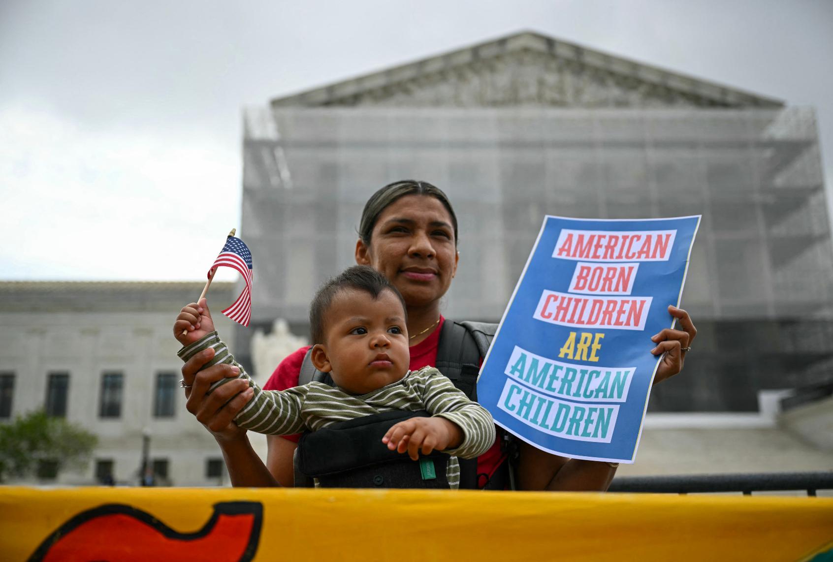 Olga Urbina and her 9=month-old son Ares Webster participate in a protest outside the Supreme Court over President Donald Trump's move to end birthright citizenship as the court hears arguments over the order in Washington, DC, on May 15, 2025. (DREW ANGERER/AFP via Getty Images)