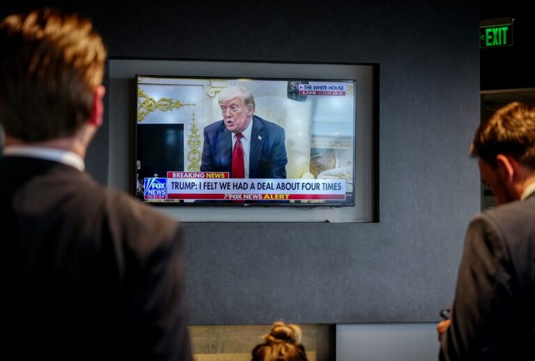 German journalists from the Defense Minister's delegation watch U.S. President Donald Trump on television during a press conference at the White House. (Kay Nietfeld/picture alliance via Getty Images)