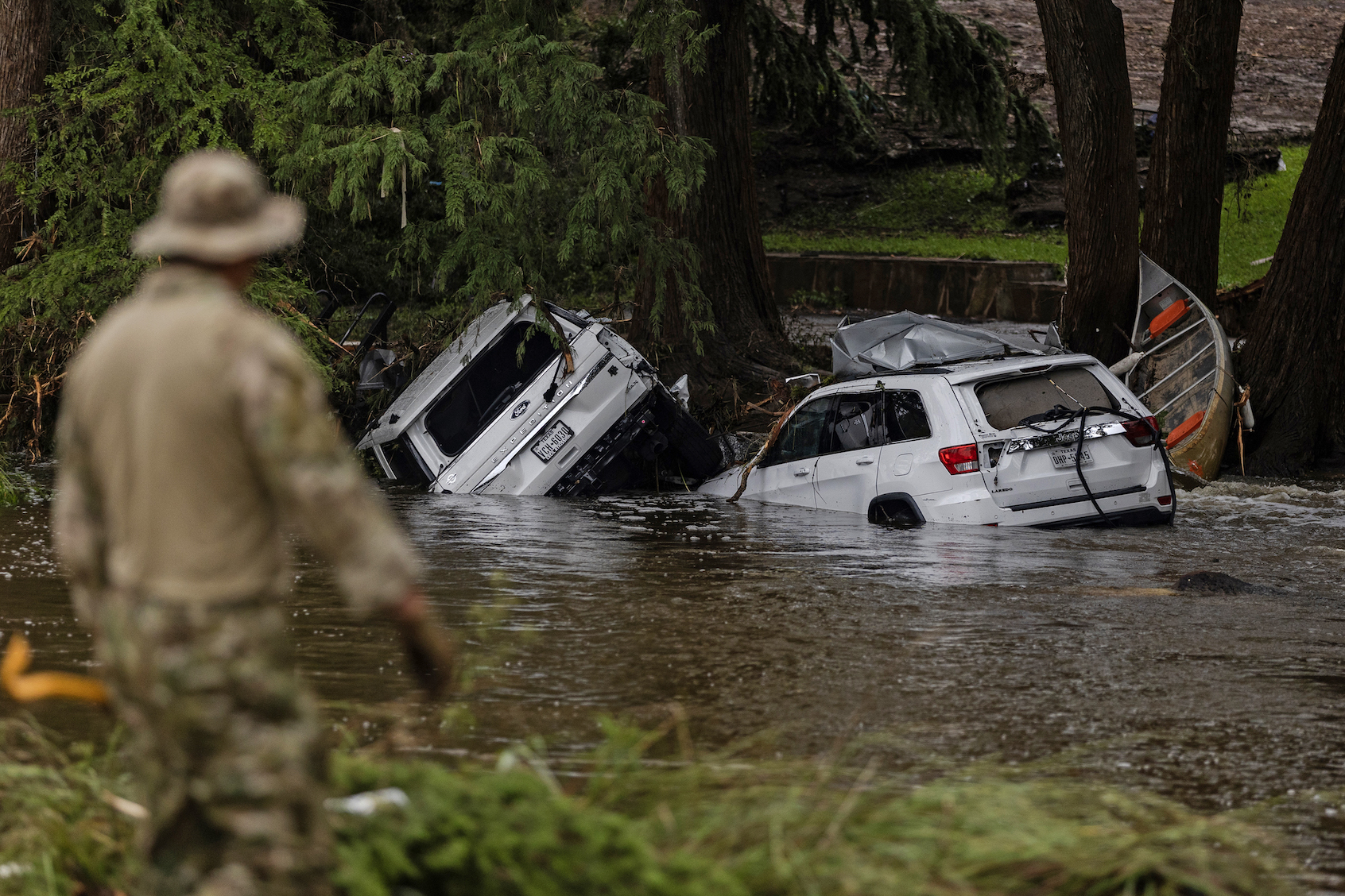 Search and rescue workers search near debris looking for any survivors or remains of people swept up in the flash flooding. (Photo by Jim Vondruska/Getty Images)