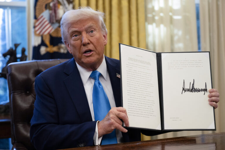 US President Donald Trump shows an executive order withdrawing his country from a number of United Nations bodies. (Photo by Andrew Caballero-Reynolds/Getty Images)