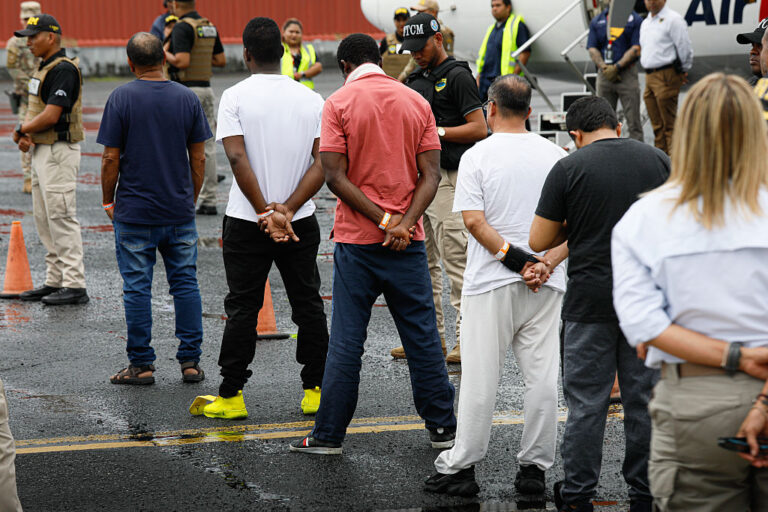 Individuals in ICE custody walk toward a deportation plane. A White House video featuring similar images and viral audio from a Jet2 ad sparked backlash. (Daniel Gonzalez / Anadolu / Getty Images)