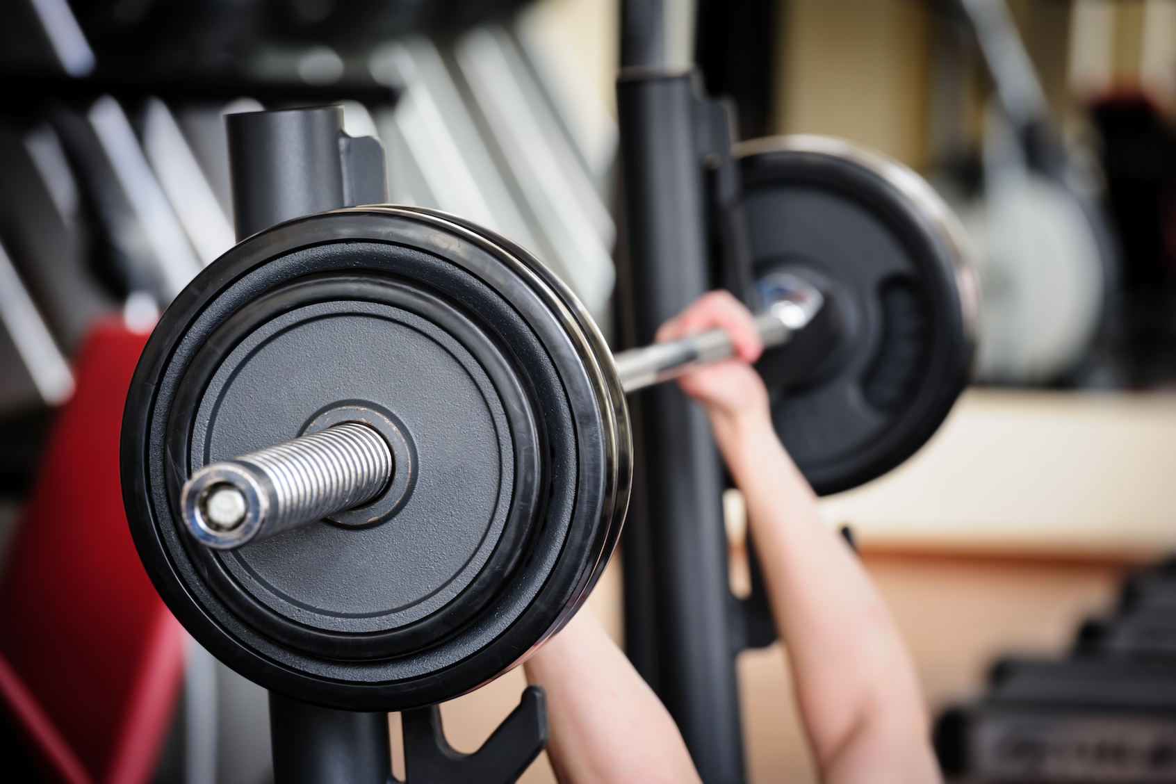 A barbell being lifted to start a bench press. (Photo via Getty Images)