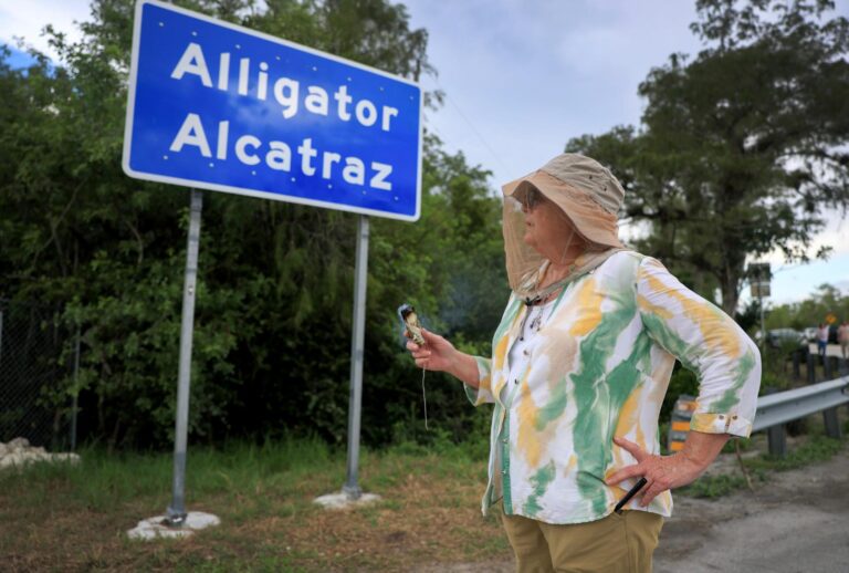 Mary Kay burns incense at the entrance to the state-managed immigration detention center dubbed Alligator Alcatraz, located at the Dade-Collier Training and Transition Airport in the Florida Everglades on August 03, 2025 in Ochopee, Florida. (Joe Raedle/Getty Images)