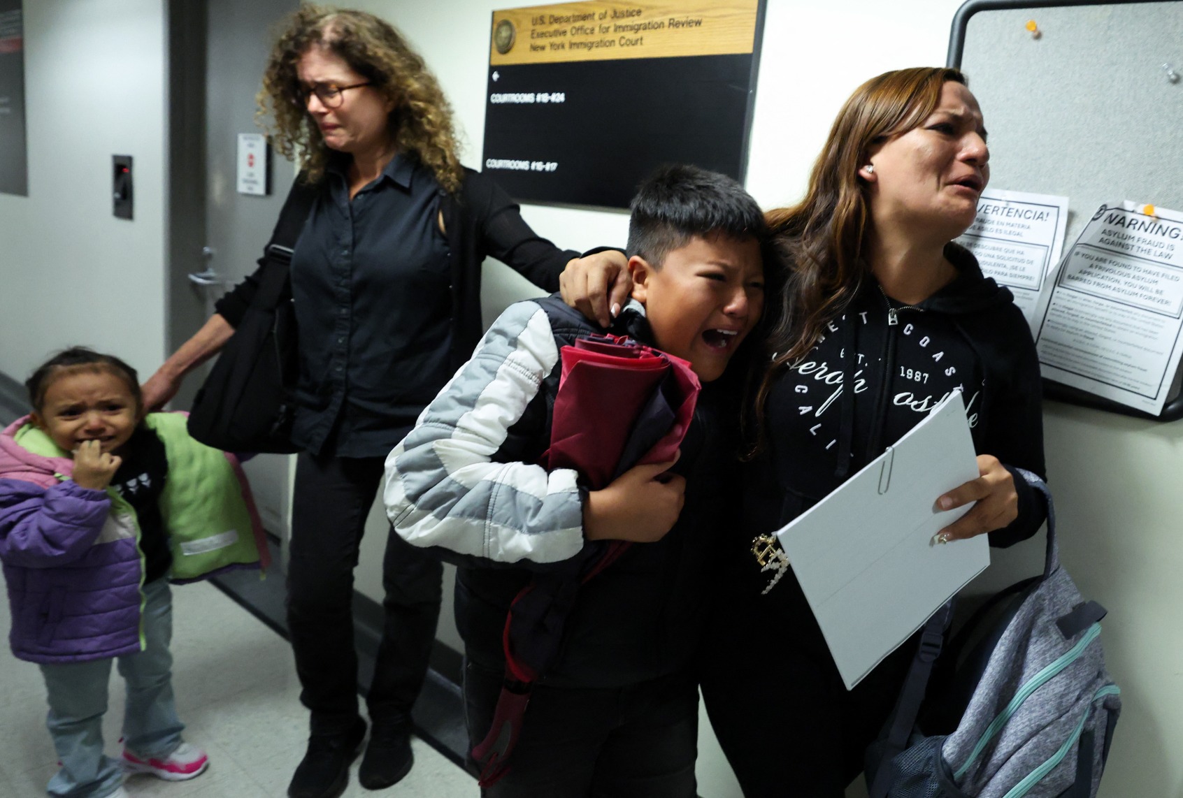 The distraught wife and crying children of a man detained by federal agents outside the courtroom where his hearing took place at the New York Federal Plaza Immigration Court, August 20, 2025. (CHARLY TRIBALLEAU/AFP via Getty Images)
