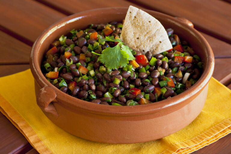 Black bean salad in an earthen ceramic bowl. (SharonFoelz/Getty Images)