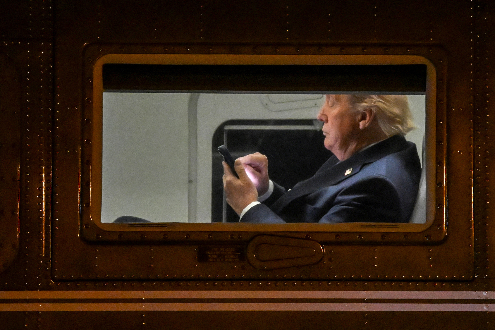 Donald Trump uses a cellphone aboard Marine One before it departs Leesburg Executive Airport. (Photo by Alex Wroblewski/Getty Images)