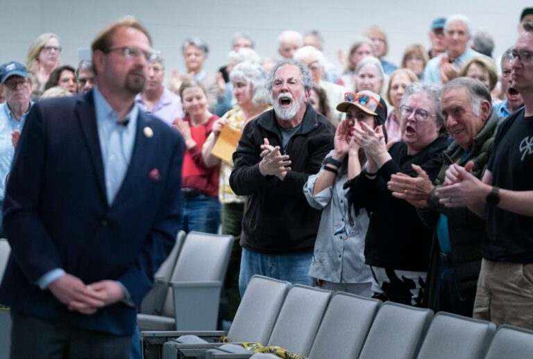Attendees react during a congressional town hall meeting with Rep. Chuck Edwards (R-NC), left, on March 13, 2025 in Asheville, North Carolina. (Sean Rayford/Getty Images)