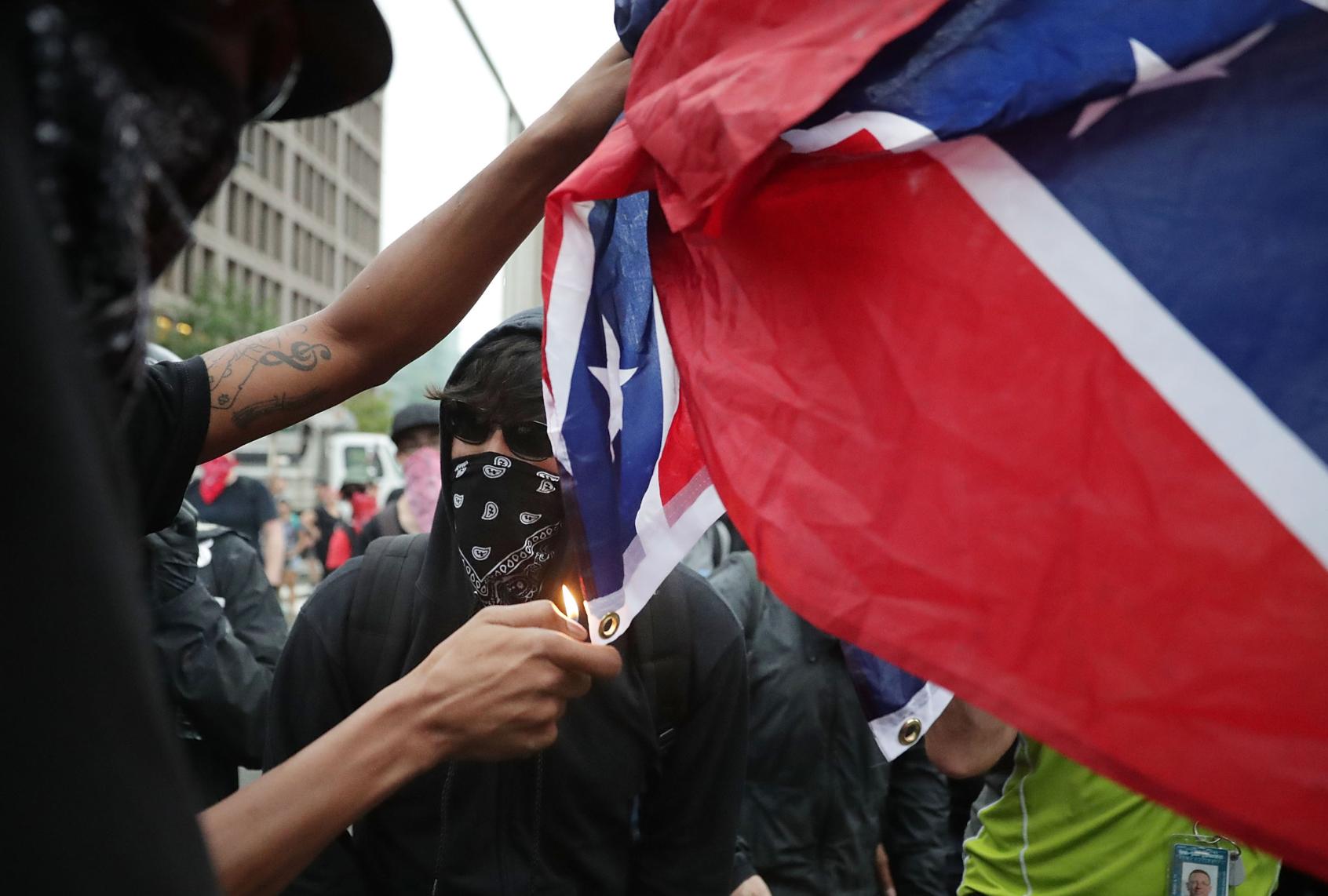 Protesters burn a Confederate battle on Aug. 12, 2018. (Chip Somodevilla/Getty Images)