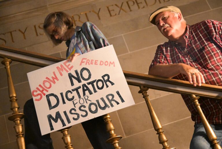 Activists display signs during a press conference inside the rotunda of the Missouri State Capitol Building on September 10, 2025 in Jefferson City, Missouri. (Michael Thomas/Getty Images)