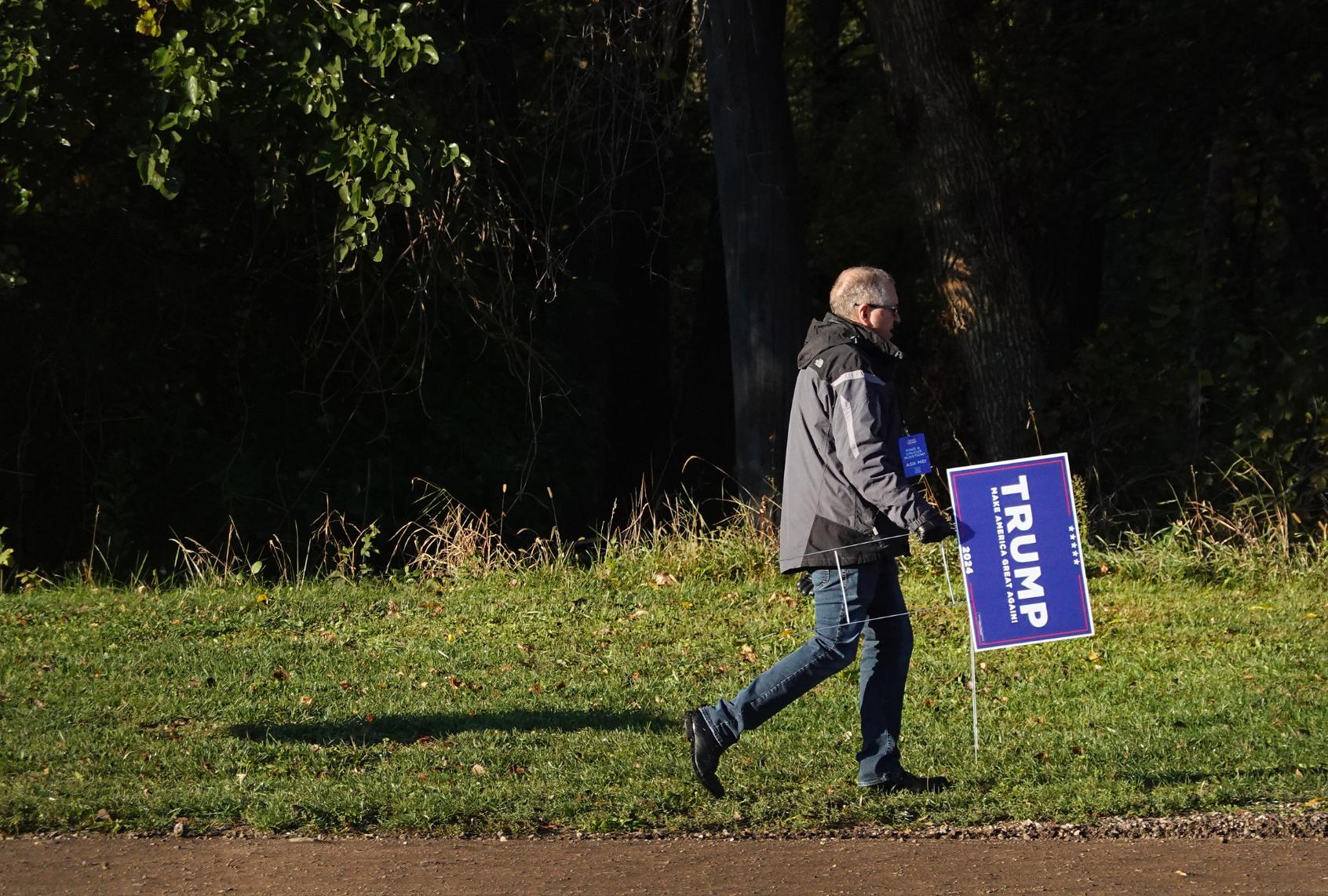 A worker sets up signs at the Dallas County Fairgrounds for a rally with Republican presidential candidate former President Donald Trump on October 16, 2023 in Adel, Iowa. (Scott Olson/Getty Images)
