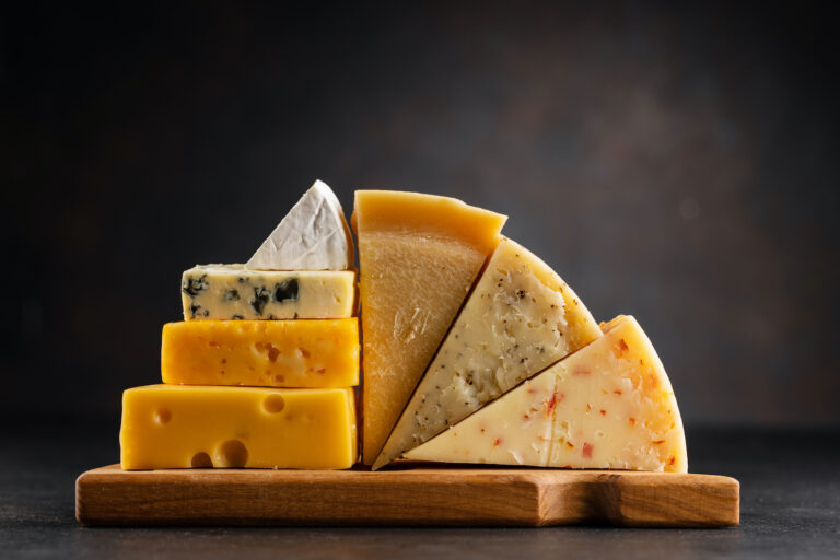 Various cheese on board on stone table (karandaev / Getty Images )