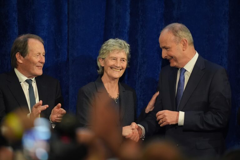 President-elect Catherine Connolly with her husband, Brian McEnery (left), and Taoiseach Micheál Martin after being declared the winner of Ireland's presidential election, Oct. 25, 2025. (Niall Carson/PA Images via Getty Images)