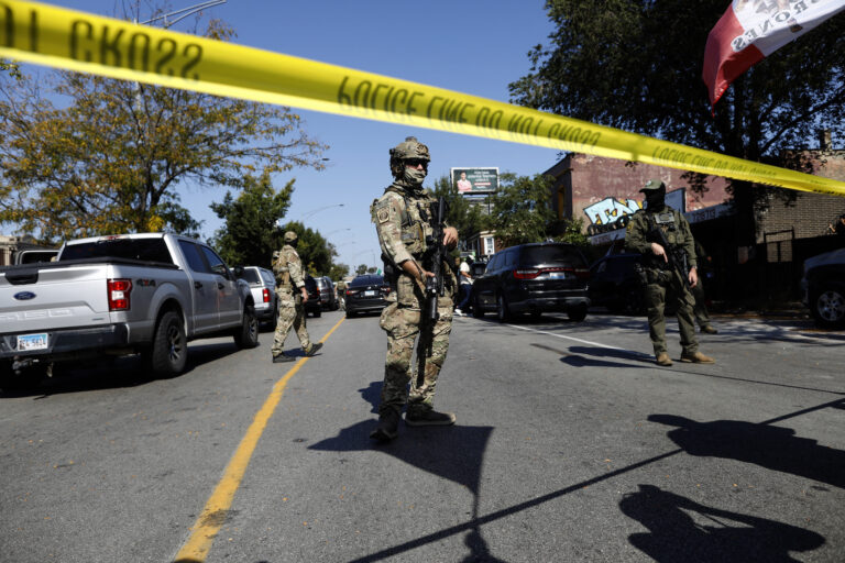 Masked US Customs and Border Protection (CBP) Border Patrol agents stand behind a police line in Chicago. (Photo by Octavio Jones/Getty Images)