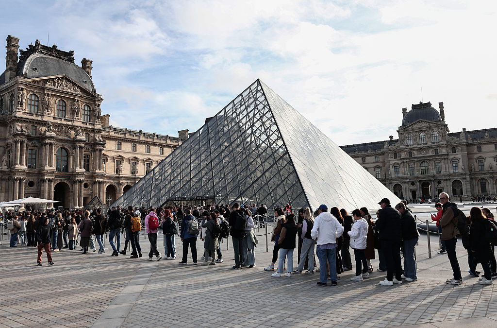 Three days after the heist, the Paris landmark reopened its doors to the public. How many were hoping for a peek at the scene of the crime rather than enjoying the art on the wall? (THIBAUD MORITZ / AFP / Getty Images)